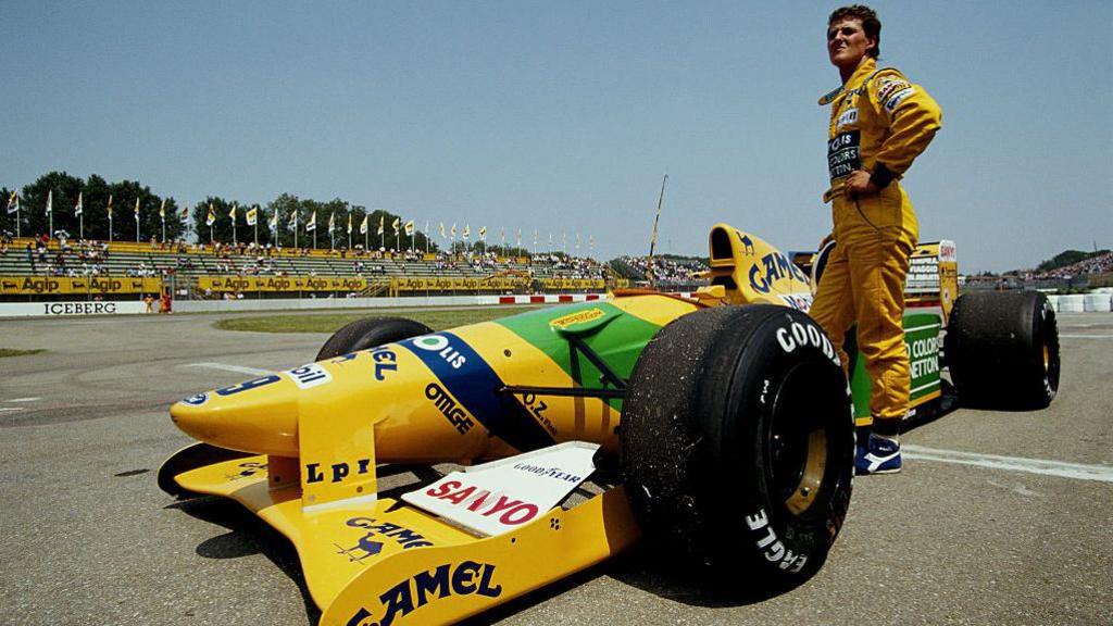 Michael Schumacher stands besides his Benetton after retiring from the 1992 San Marino Grand Prix 