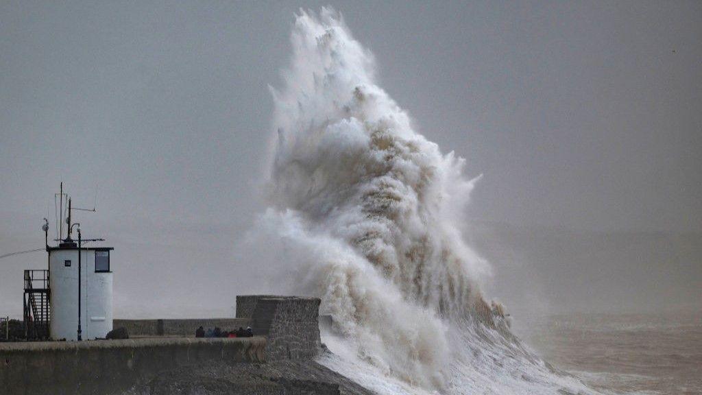 A massive wave crashes over a light house in Porthcawl, Wales