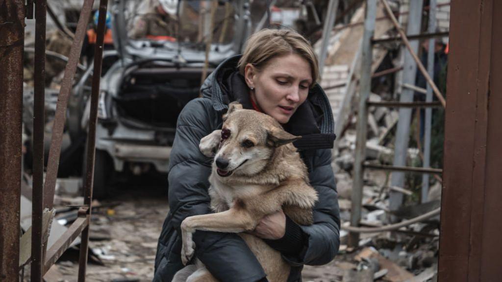 A woman carries her wounded dog from the site of a Russian kamikaze drones' strike in Mykolaiv, Ukraine. 