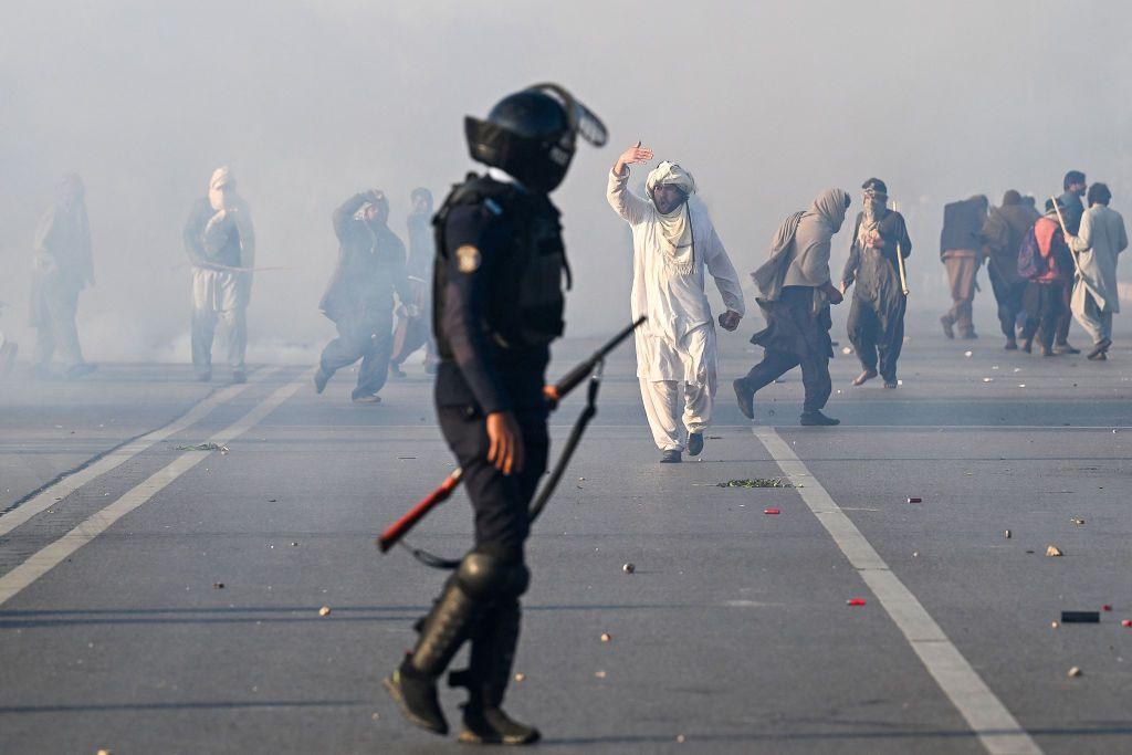 Policemen fire tear gas shells to disperse supporters of Imran Khan during a protest to demand his release