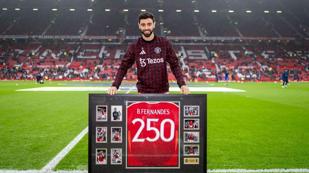 Bruno Fernandes of Manchester United is presented with a shirt to mark his 250th appearance for the club before the game against Leicester City