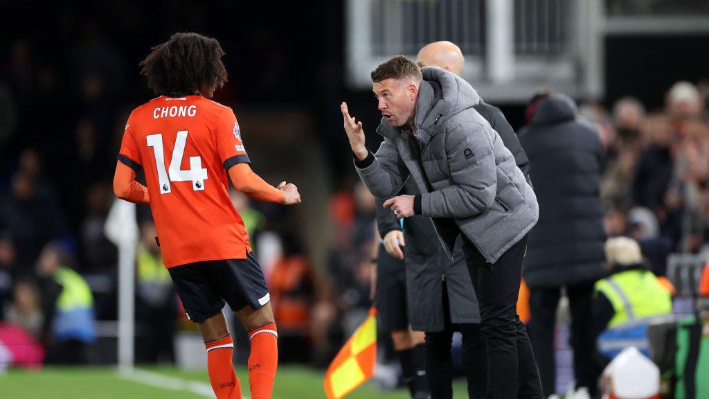 Tahith Chong of Luton Town speak with manager Rob Edwards