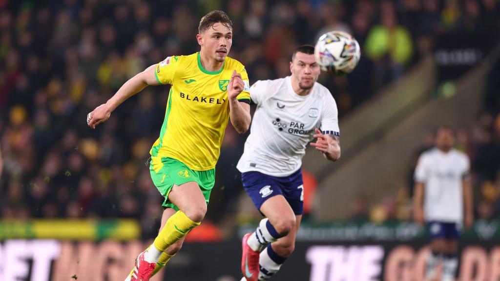 Norwich City's Callum Doyle competes with a Preston player as they chase a bouncing ball during a match