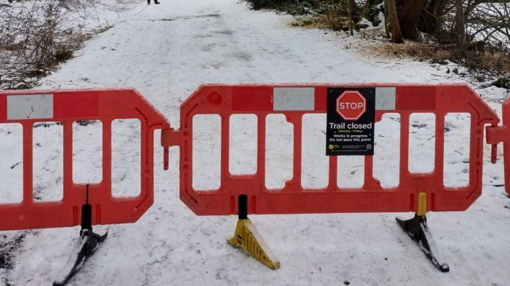 The Monsal Trail covered in snow with a red barrier and a "stop trail closed sign" at the front of the photo.