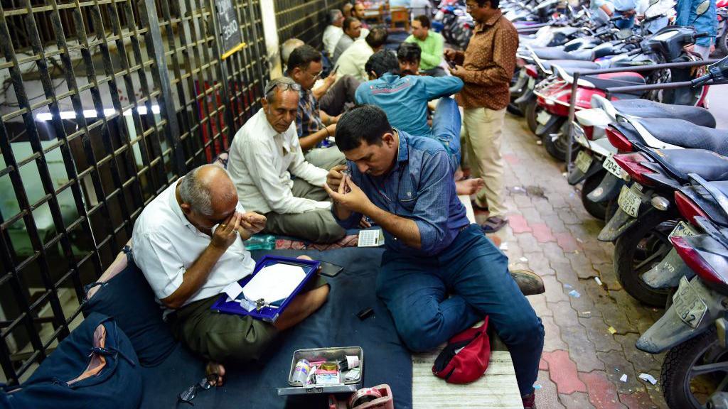 This photograph taken on February 7, 2024 shows diamond traders gathered at the main market in Surat