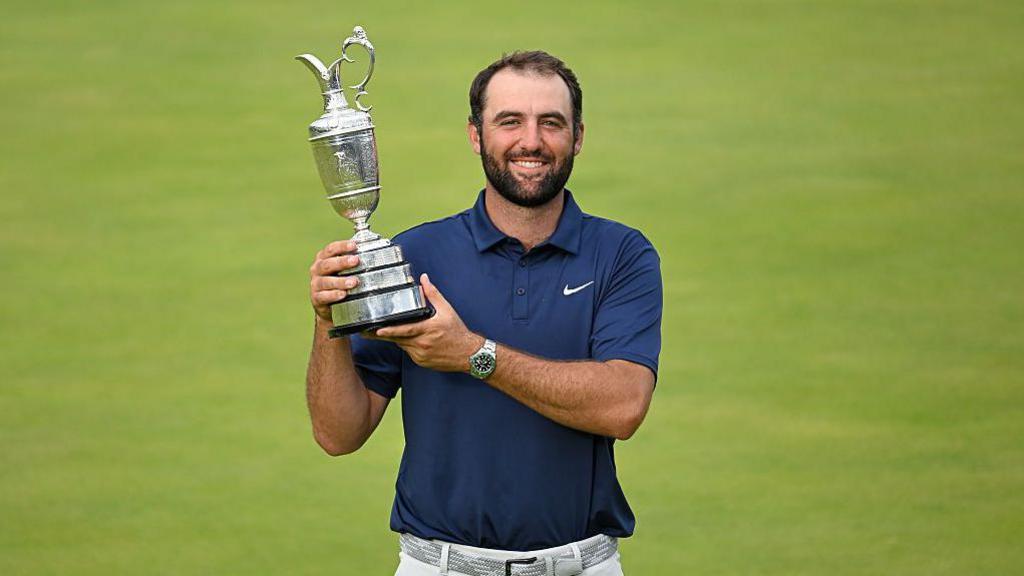 Scottie Scheffler holding The Open Championship trophy