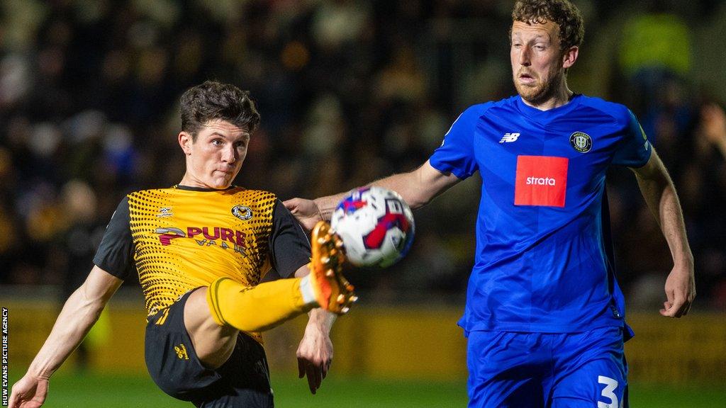 Newport's Charlie McNeill attempts to clear the ball away from Joe Mattock