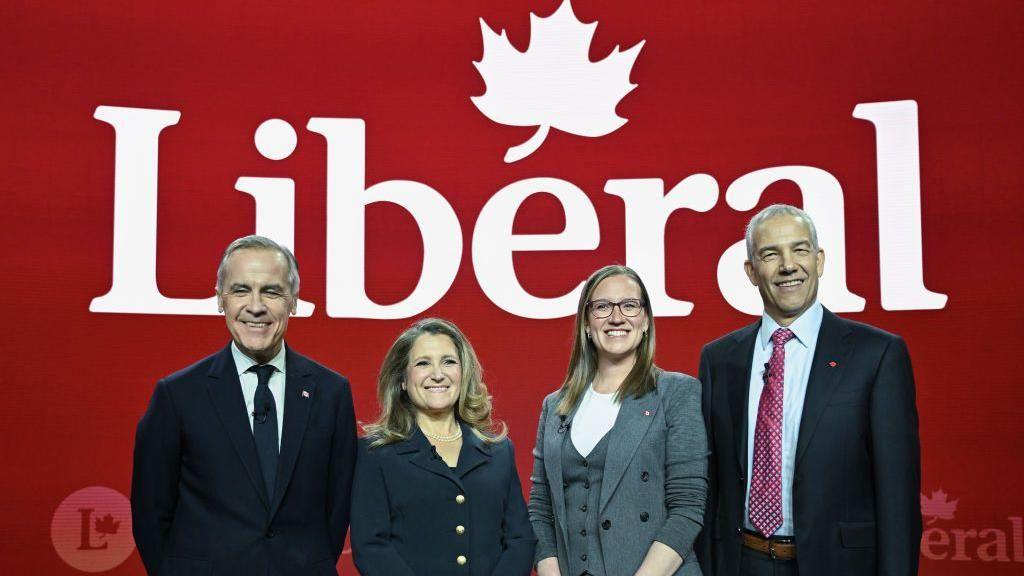 Candidates vying for Liberal Party leadership pose before Monday's debate in front of a large Liberal Party banner