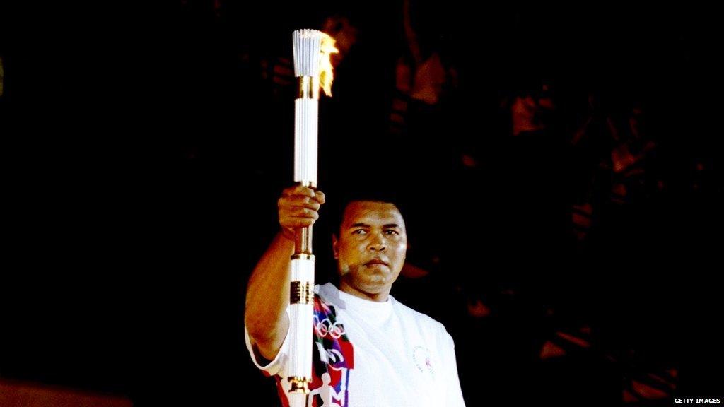 Muhammad Ali holds up the 1996 Olympic torch.