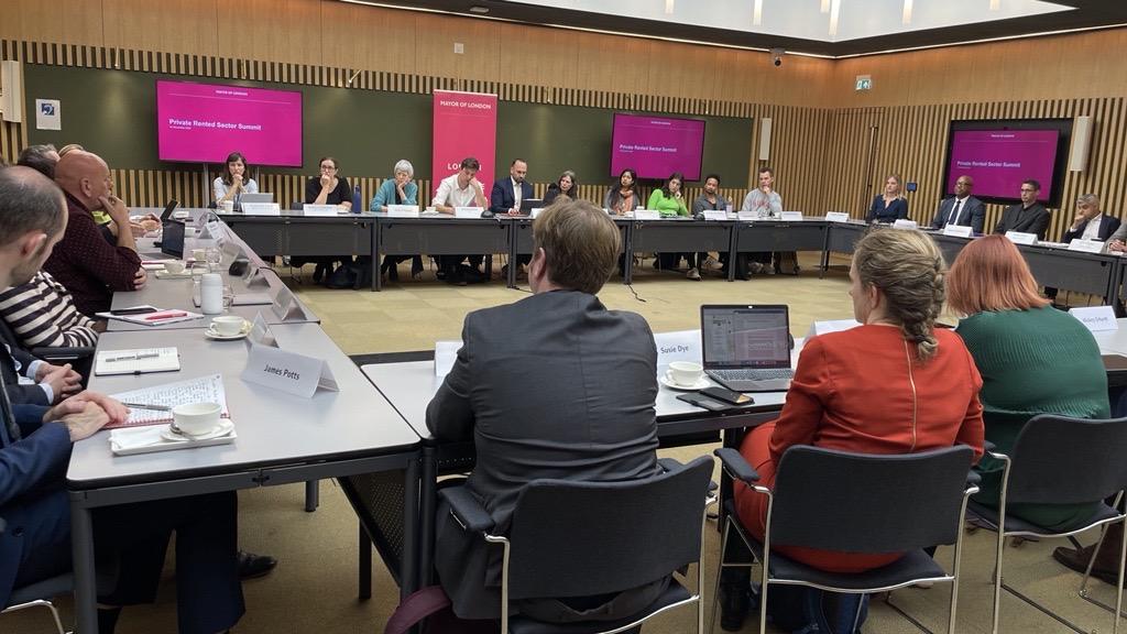 People sitting around desks at an emergency summit on renting in London 