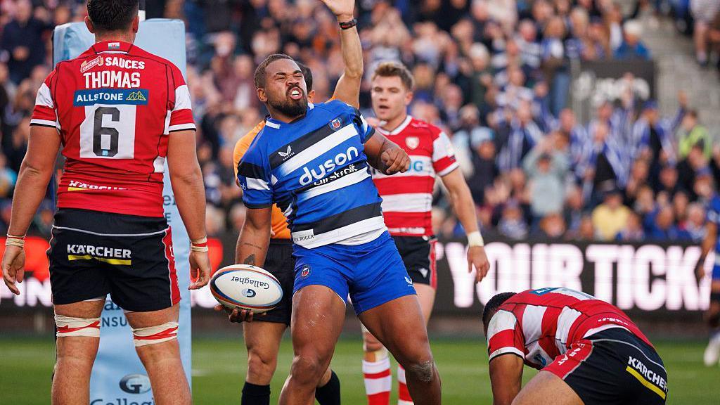 Ollie Lawrence celebrates scoring a try as three Gloucester players look disconsolate in the background