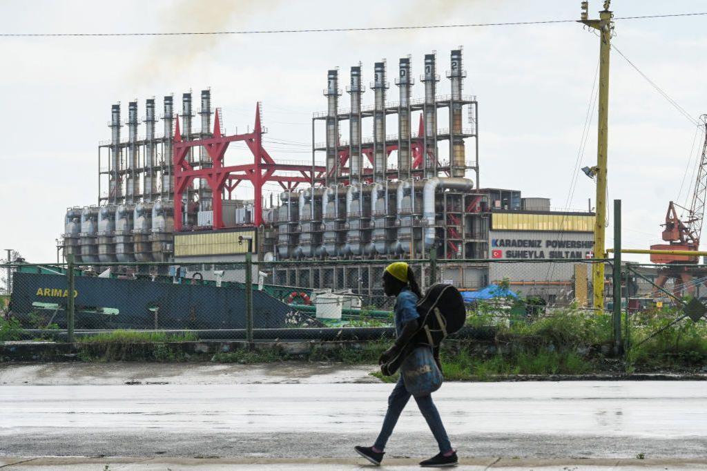 A Cuban walks next to a floating power plant in Havana Harbour on October 21, 2024.