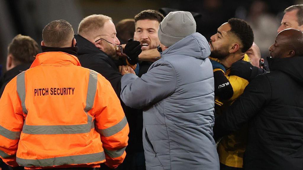 Matheus Cunhas appears to snatch a pair of glasses off the face of a member of Ipswich's security team 