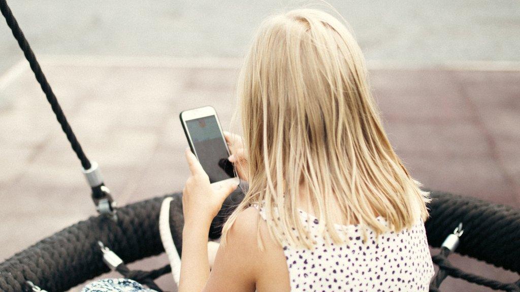 Stock photo of a child with a phone