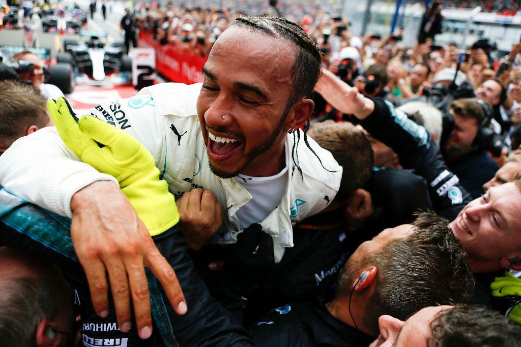 Lewis Hamilton jumps on Mercedes mechanics in celebration after winning the 2018 German Grand Prix