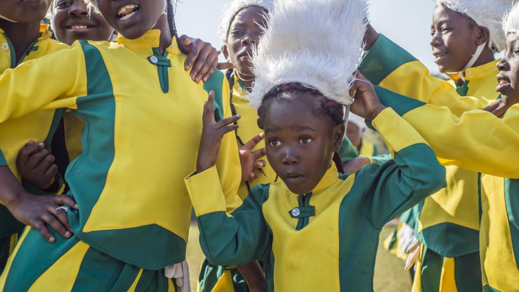 Young girl wearing yellow and green uniform