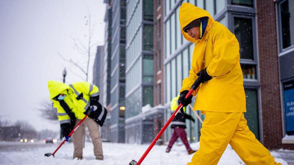 Workers cleaning up snow in Washington DC on 6 January. 