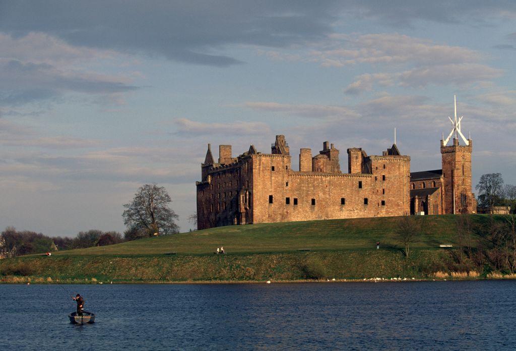 Linlithgow Palace and St Michael's Parish Church with a boat on Linlithgow Loch