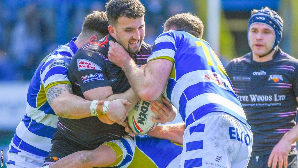 Will Maher of Halifax looks to stop Barrow's Sam Brooks as he powers forward