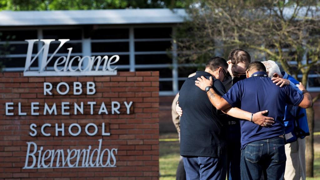 People gather at Robb Elementary School