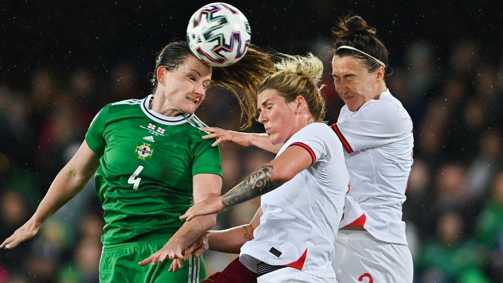 Sarah McFadden beats England pair Millie Bright and Lucy Bronze to the high ball in April's World Cup qualifier in Belfast