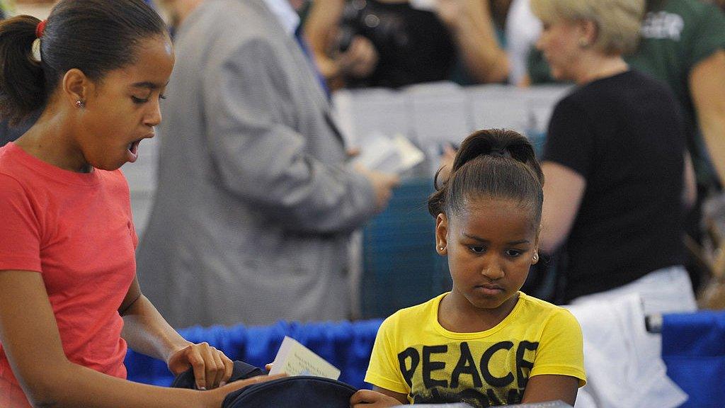 Malia and Sasha prepare backpacks for the children of service personnel, 2009