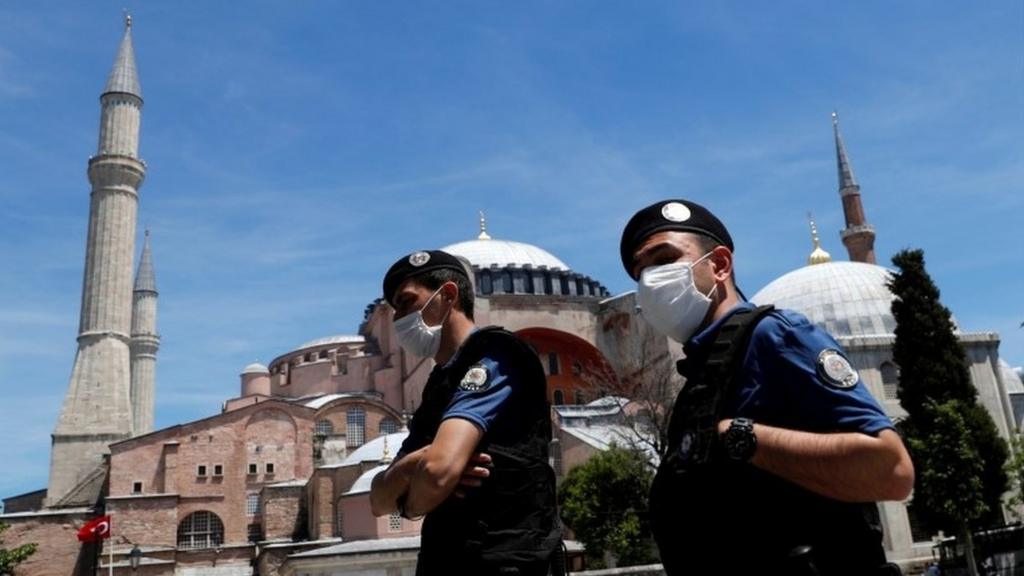 Turkish police officers wearing face masks, with the Byzantine-era monument of Hagia Sophia, now a museum, in the background, patrol at touristic Sultanahmet Square following the coronavirus disease (COVID-19) outbreak, in Istanbul, Turkey, June 5, 2020.