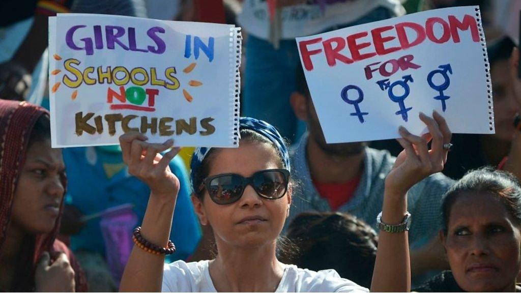 Women holding protest signs