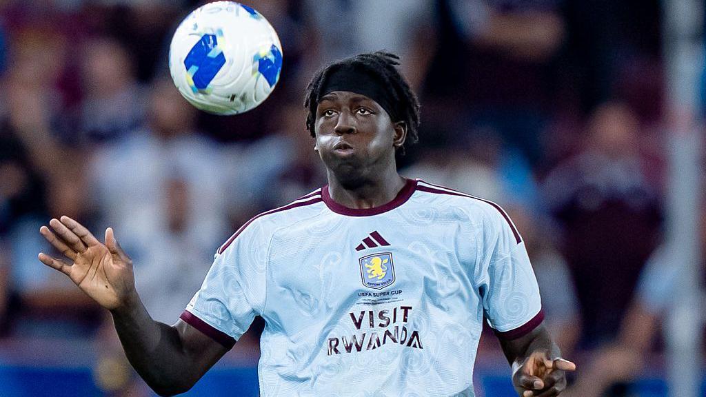 Brian Madjo playing for Aston Villa watches the ball as he's about to control it on his chest. 