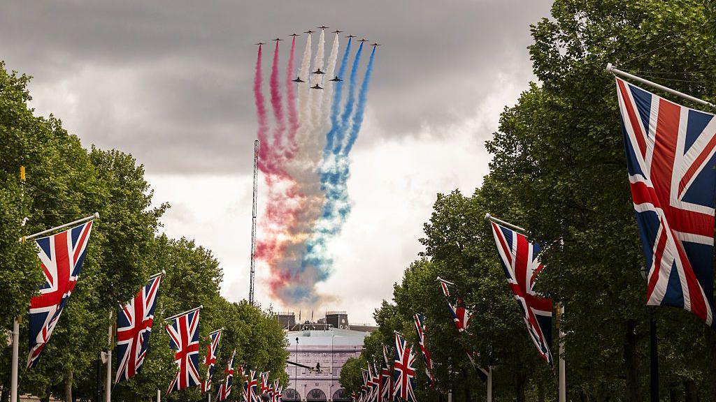 Aircraft from the British Royal Air Force's (RAF) Red Arrows perform a fly past over the Mall during the VE Day 80 procession