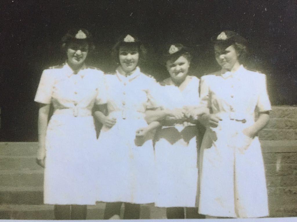 A black-and-white photo of Anne Puckridge and three other young women wearing military uniform.