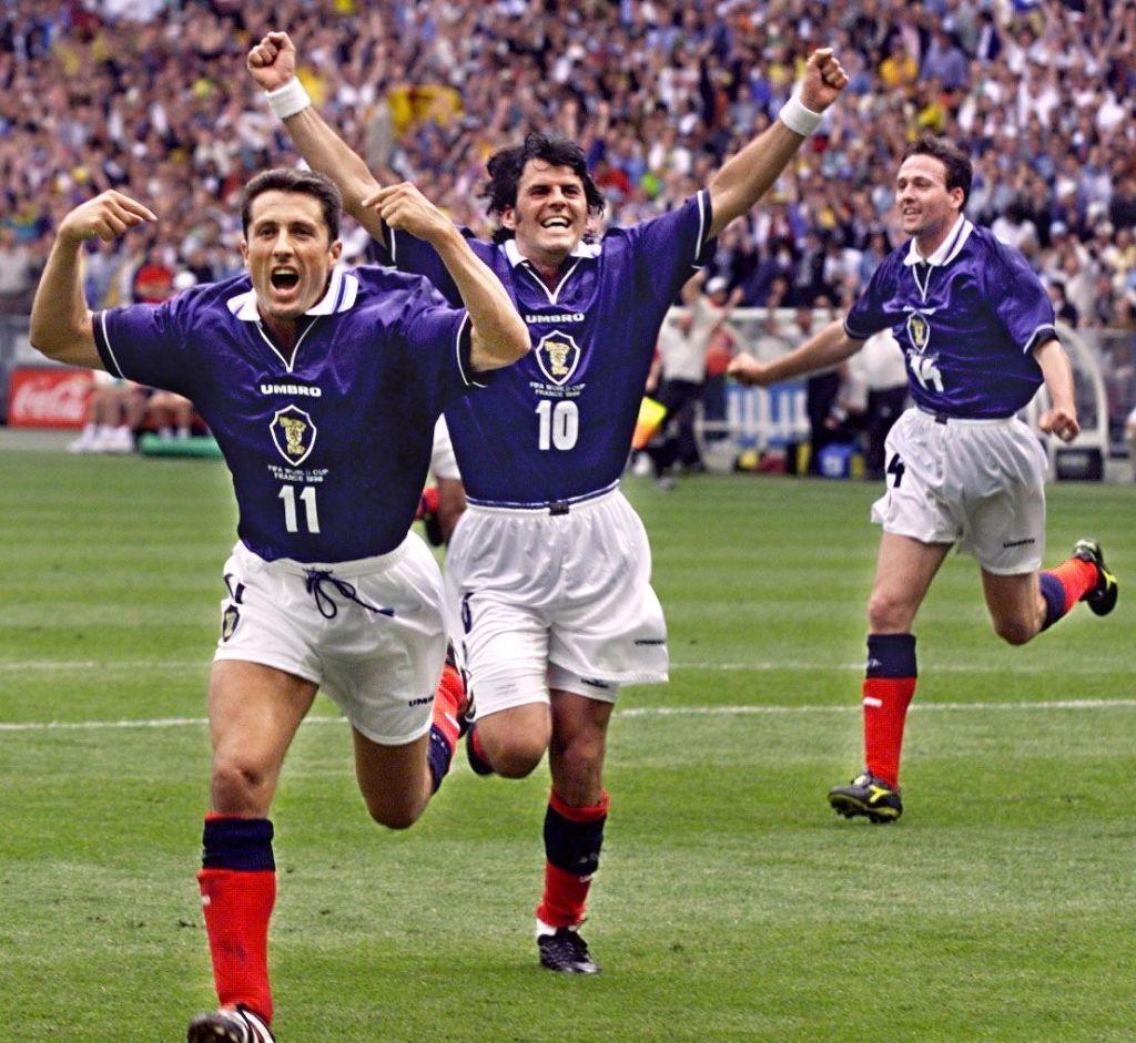 Scottish forwards John Collins (L) and Darren Jackson (C) celebrate on the pitch  after Collins scored a penalty on 10 June at the Stade de France in Saint Denis during the 1998 Soccer World Cup group A first round match against Brazil. Brazil and Scotland are tied 1-1 in the second half. 
