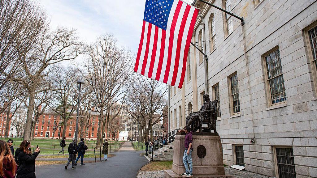 view of side of Harvard campus with large American flag hanging from building