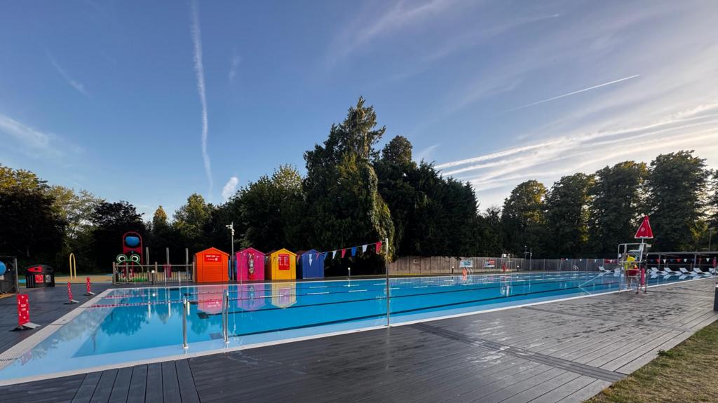 An outdoor swimming pool on a sunny morning.