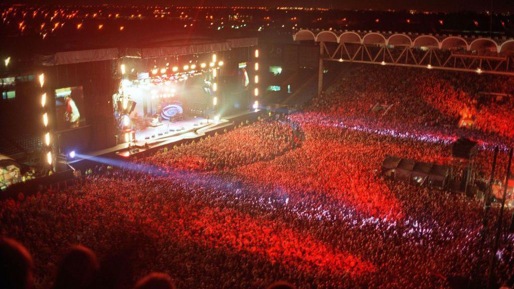 Oasis playing a concert in front of a huge crowd