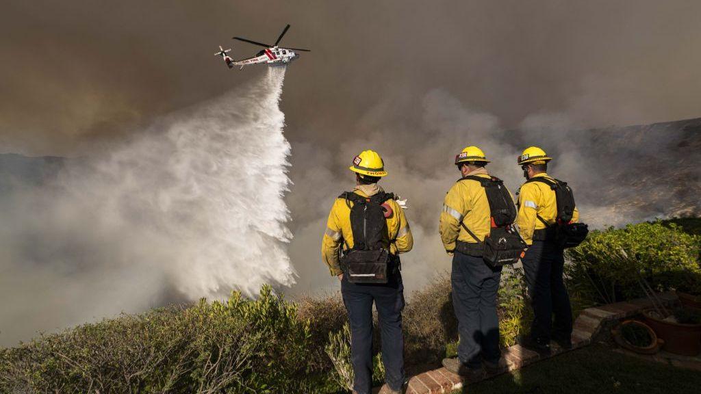 Monterey County Firefighters watch as a LA County helicopter comes in to make a water drop on the Palisade Fire