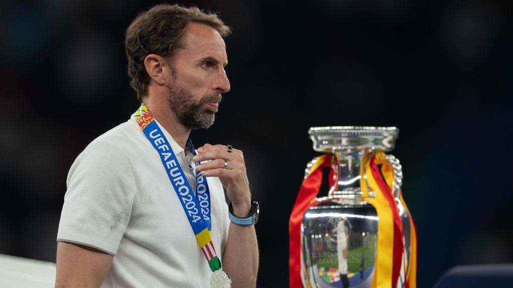 Gareth Southgate walking past the European Championship trophy