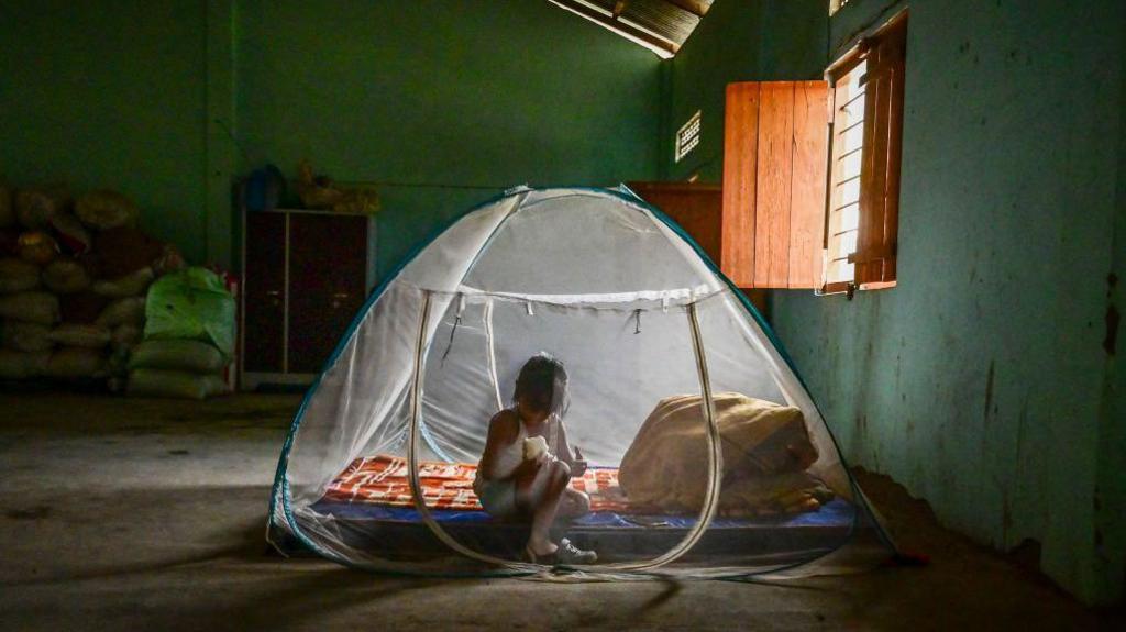 A child from Kuki ethnic group sits inside a tent at a relief camp for internally displaced people on April 27, 2024 in Litan village, Manipur, India. 