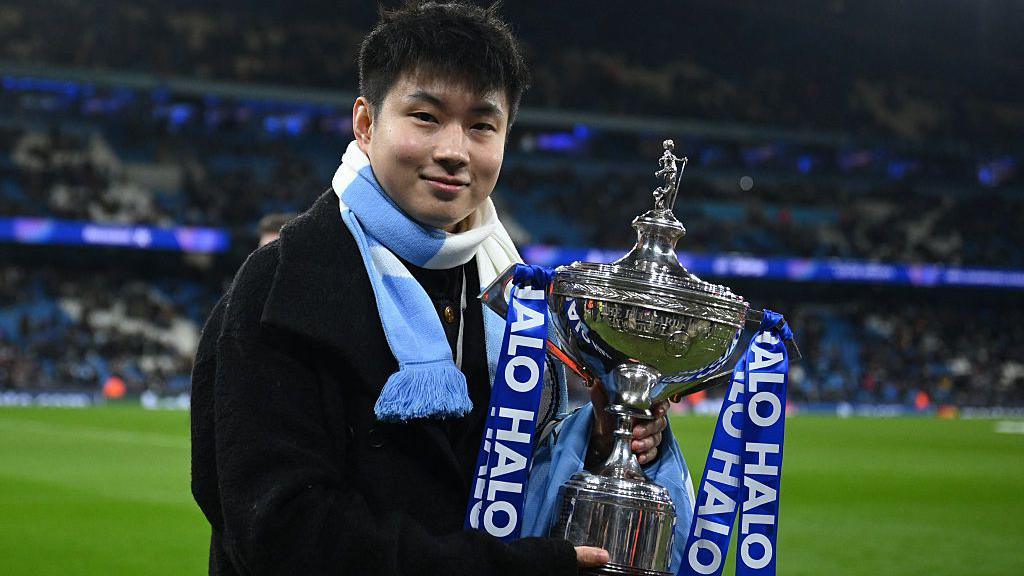 Zhao Xintong at Manchester City holding the World Championship trophy