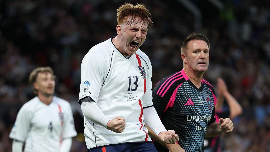 Angry Ginge celebrates after making a clearance for England during last year's Soccer Aid, at Old Trafford in June 2025