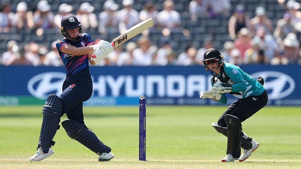 Scotland's Darcey Carter hits a shot as New Zealand wicket keeper Izzy Gaze looks on during the women's T20 World Cup