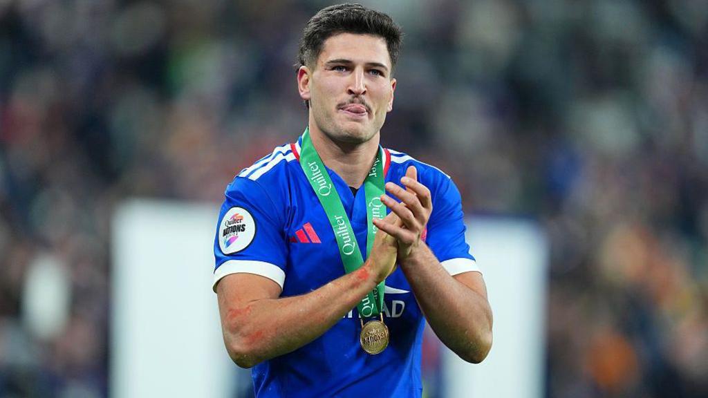 Nicolas Depoortere claps with a medal around his neck