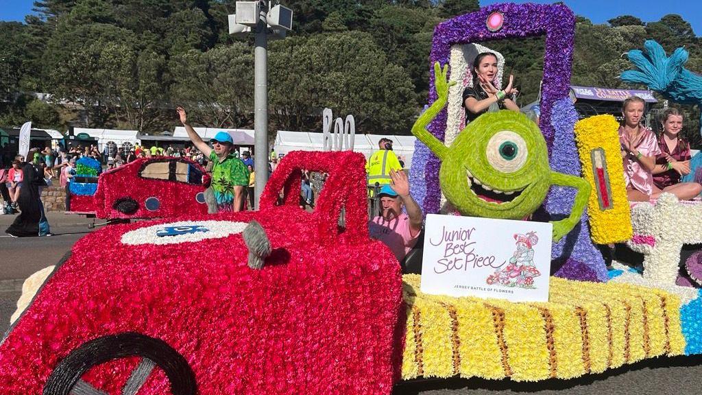 A float at a Battle of Flowers event in Jersey. It is covered in flowers with a designed based on the film Monsters Inc, with the character Mike featuring.