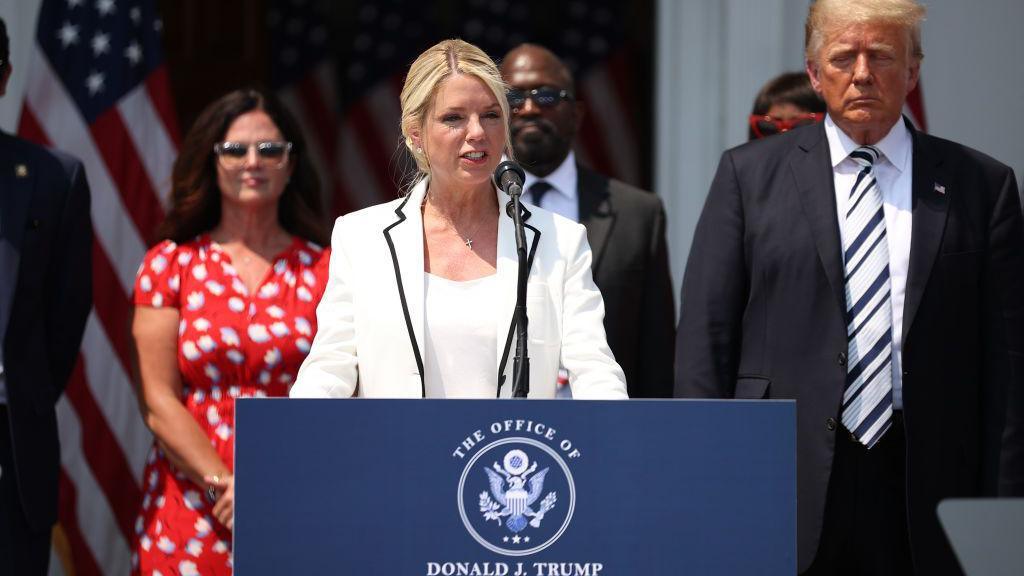 Pam Bondi stands next to Donald Trump as she speaks during a press conference on 7 July, 2021