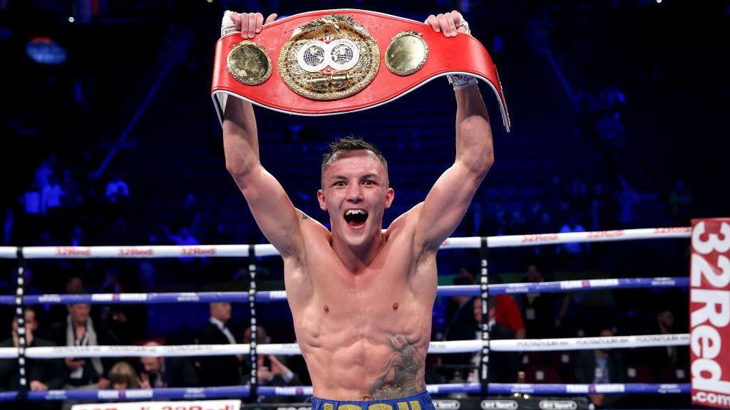 Josh Warrington holds his IBF belt over his head