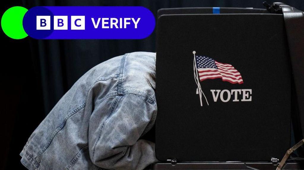 Person filling out a ballot in a voting booth