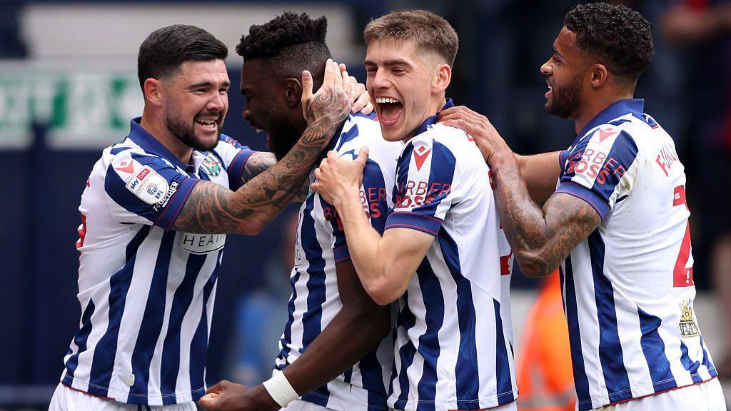 Daryl Dike is surrounded by jubilant team-mates after scoring on his first league start for two years