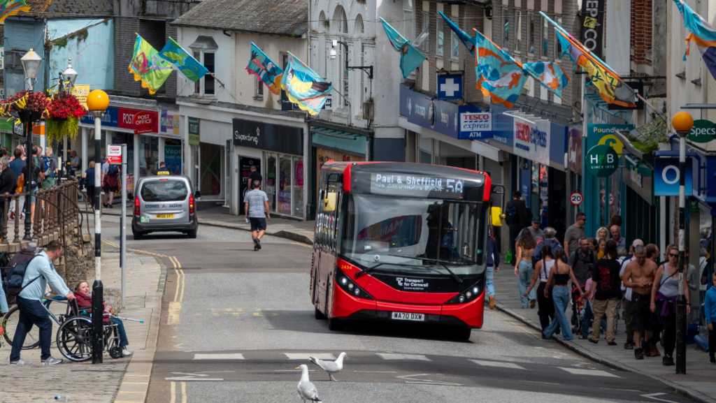 A bus driving through a Cornwall town 