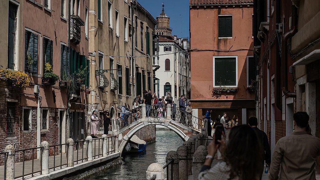 People walk on a footbridge in the Dorsoduro district on April 04, 2026 in Venice, Italy. 