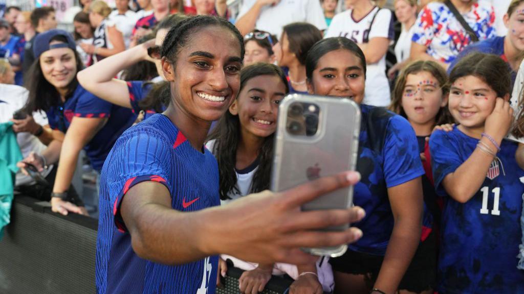 Naomi Girma taking a selfie with fans.